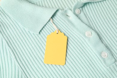 Photo of Cardboard tag on turquoise garment, top view
