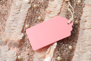 Photo of Cardboard tag on pink garment, above view