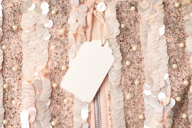 Photo of Cardboard tag on pink garment, top view