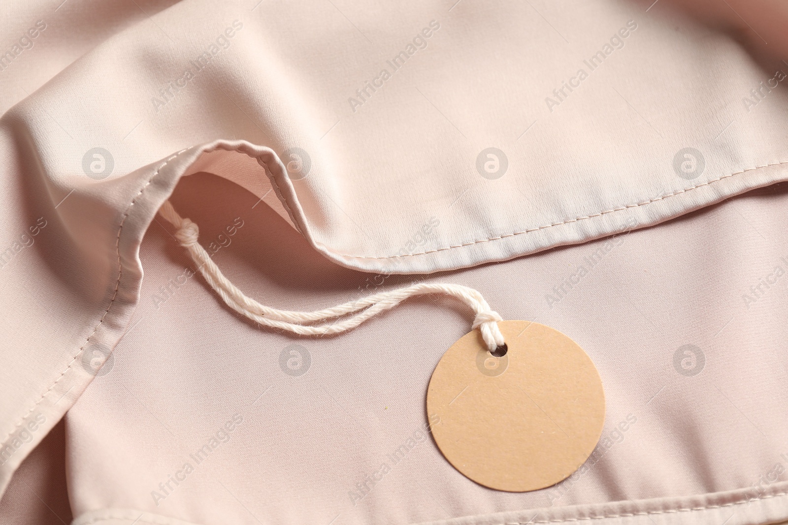 Cardboard tag on silk garment, top view Photo of Cardboard tag on silk garment, top view