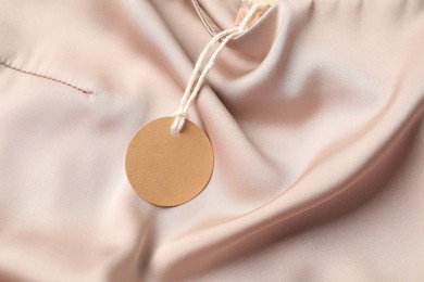 Photo of Cardboard tag on silk garment, top view