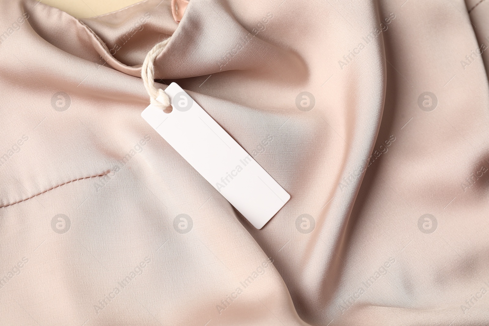 Cardboard tag on silk garment, top view Photo of Cardboard tag on silk garment, top view