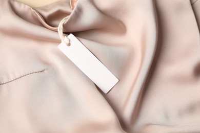 Photo of Cardboard tag on silk garment, top view