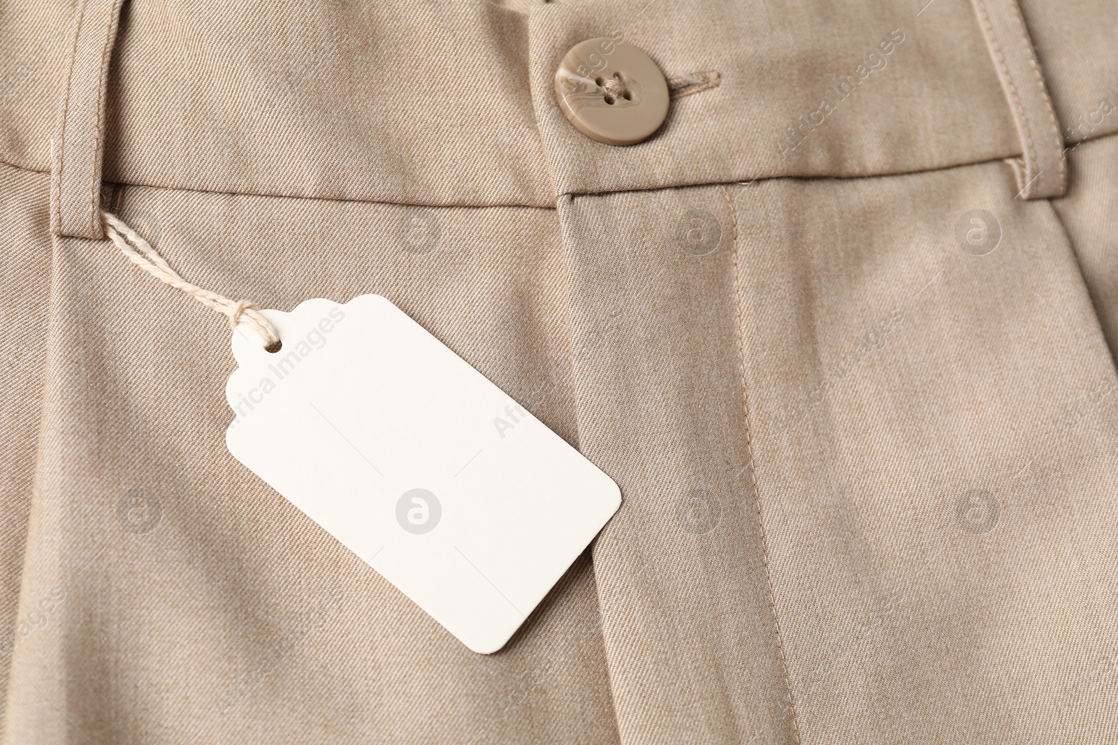 Cardboard tag on beige pants, above view Photo of Cardboard tag on beige pants, above view