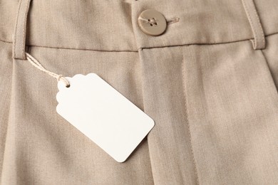 Photo of Cardboard tag on beige pants, above view