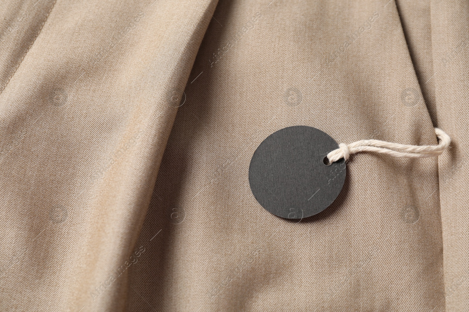 Cardboard tag on beige pants, above view Photo of Cardboard tag on beige pants, above view