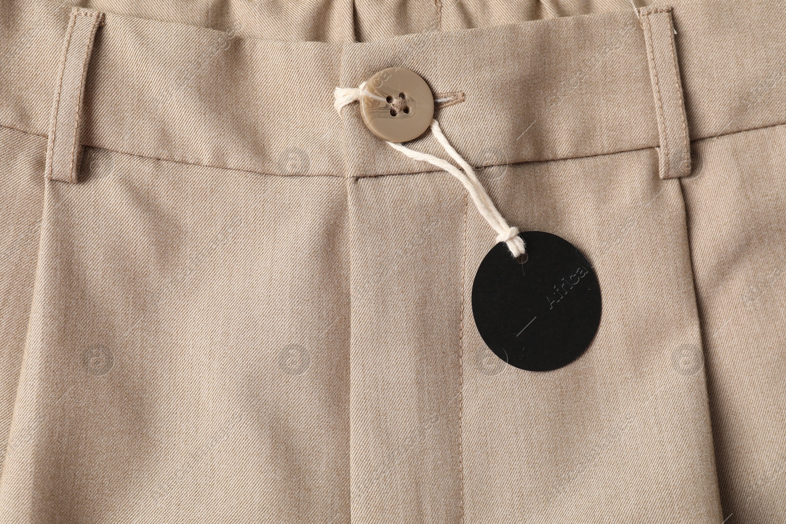 Cardboard tag on beige pants, top view Photo of Cardboard tag on beige pants, top view