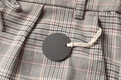 Photo of Cardboard tag on checkered pants, top view