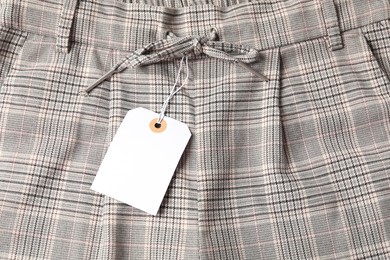 Photo of Cardboard tag on checkered pants, above view