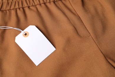 Photo of Cardboard tag on brown pants, above view