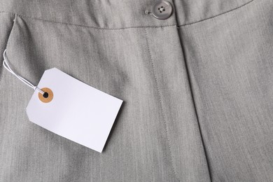 Photo of Cardboard tag on grey pants, top view