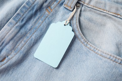 Photo of Cardboard tag on light blue jeans, above view