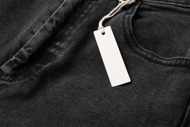 Photo of Cardboard tag on black jeans, above view