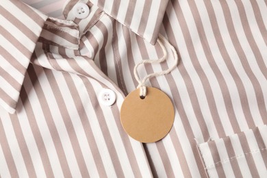 Photo of Cardboard tag on striped shirt, top view