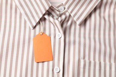 Photo of Cardboard tag on striped shirt, top view