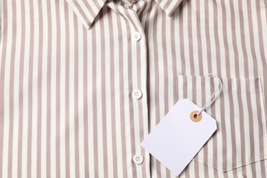 Photo of Cardboard tag on striped shirt, top view
