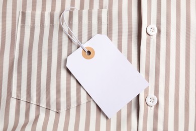 Photo of Cardboard tag on striped shirt, top view