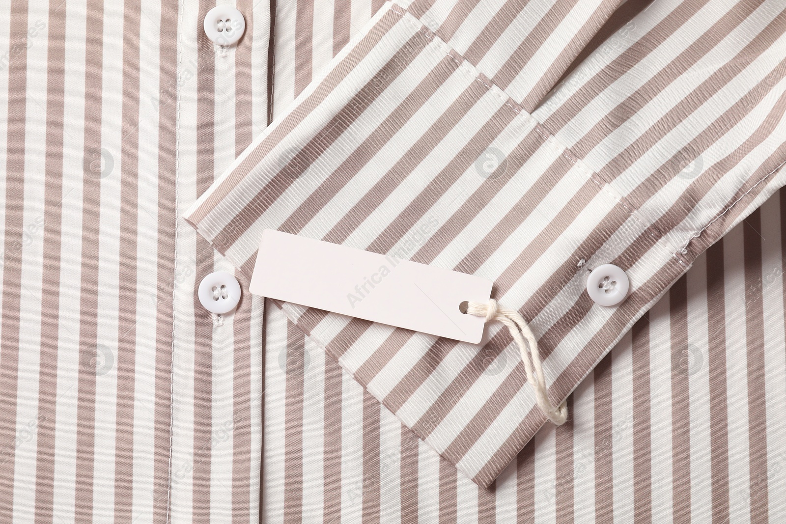 Cardboard tag on striped shirt, top view Photo of Cardboard tag on striped shirt, top view