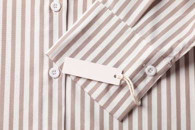 Photo of Cardboard tag on striped shirt, top view
