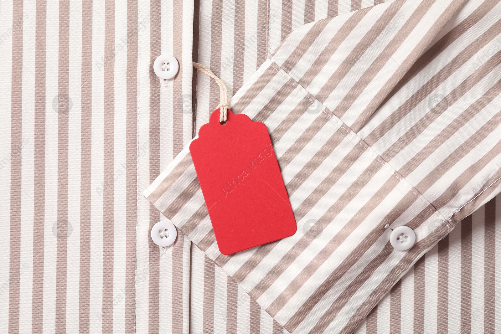 Cardboard tag on striped shirt, top view Photo of Cardboard tag on striped shirt, top view