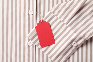 Photo of Cardboard tag on striped shirt, top view