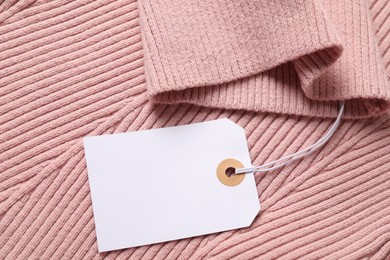 Photo of Cardboard tag on pink garment, top view