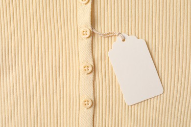 Photo of Cardboard tag on beige garment, top view