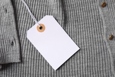 Photo of Cardboard tag on grey garment, top view
