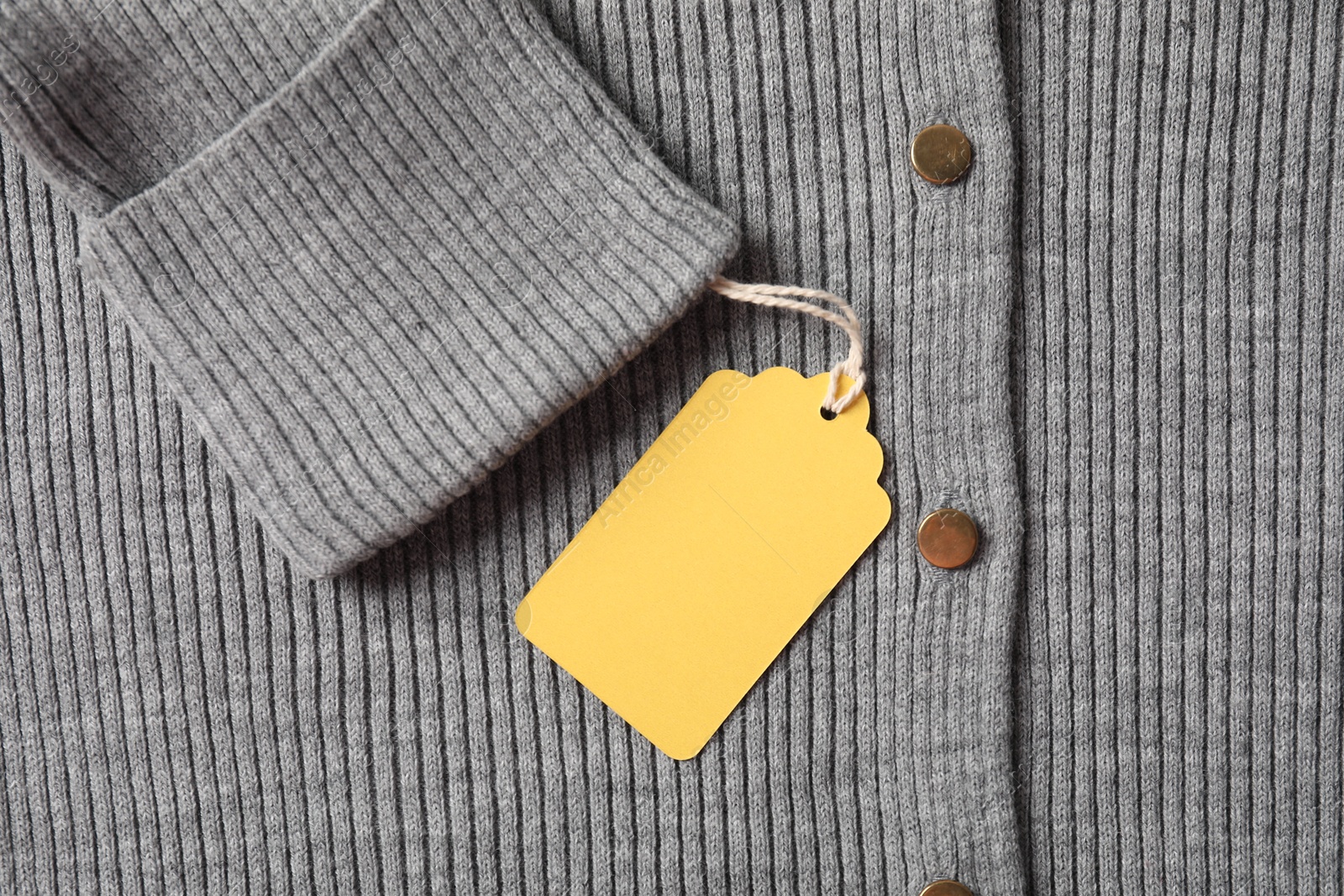 Cardboard tag on grey garment, top view Photo of Cardboard tag on grey garment, top view