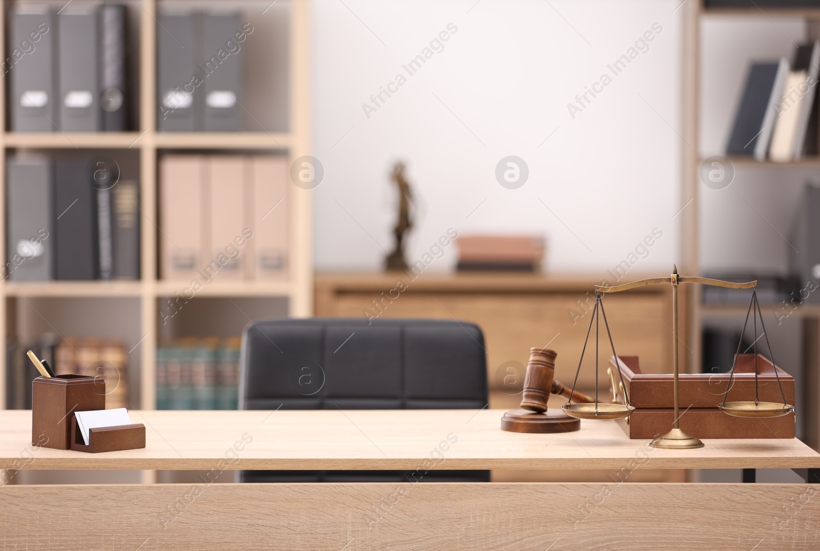Judge's gavel, scales, stationery and document tray on table in office Photo of Judge's gavel, scales, stationery and document tray on table in office