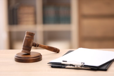 Photo of Judge's gavel and clipboards on wooden table in office, closeup