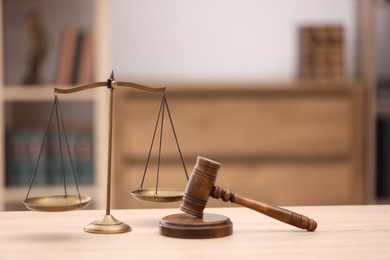 Photo of Judge's gavel and scales on wooden table in office