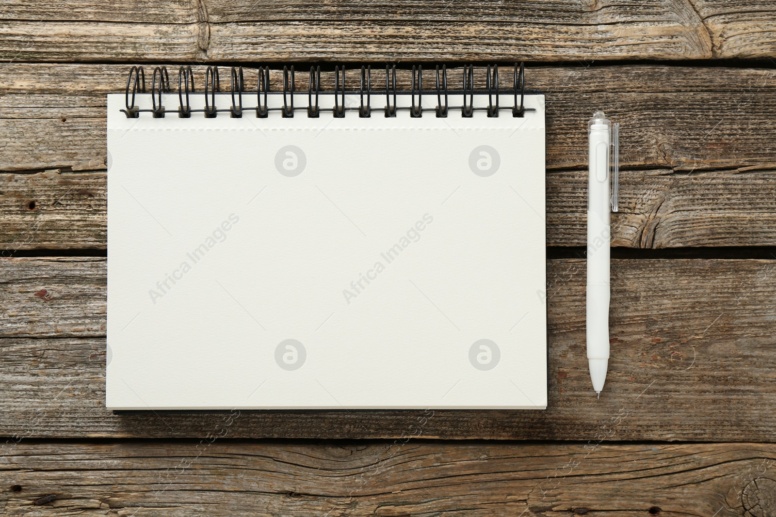 Photo of Notebook and pen on wooden table, flat lay