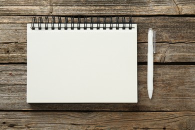 Photo of Notebook and pen on wooden table, flat lay