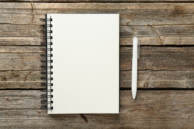 Photo of Notebook and pen on wooden table, flat lay