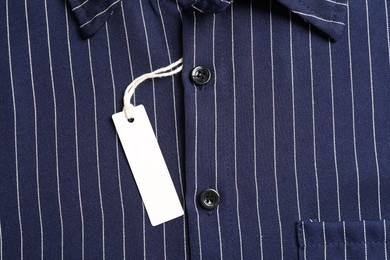 Photo of Cardboard tag on striped shirt, top view