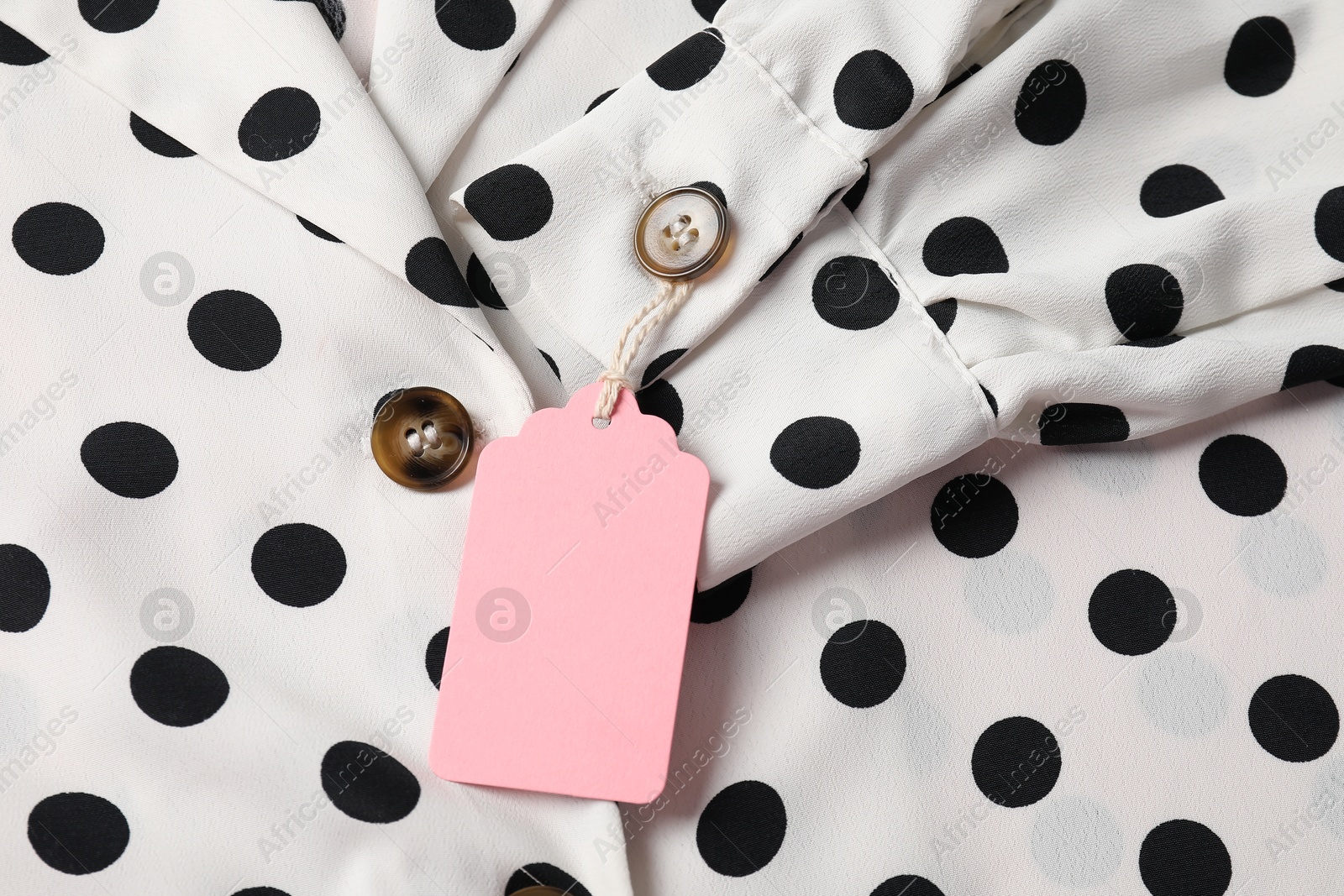 Cardboard tag on dotted shirt, top view Photo of Cardboard tag on dotted shirt, top view