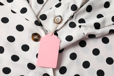 Photo of Cardboard tag on dotted shirt, top view