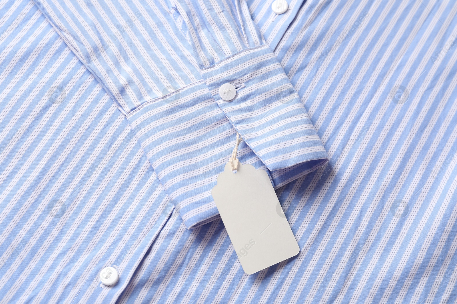 Cardboard tag on striped shirt, top view Photo of Cardboard tag on striped shirt, top view