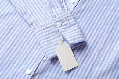 Photo of Cardboard tag on striped shirt, top view