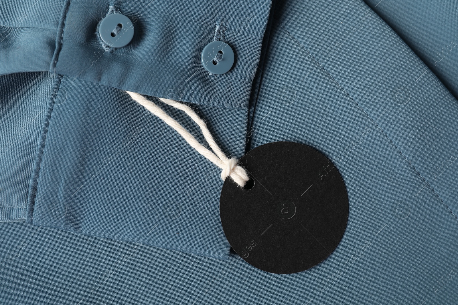 Cardboard tag on blue shirt, top view Photo of Cardboard tag on blue shirt, top view