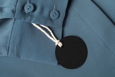 Photo of Cardboard tag on blue shirt, top view