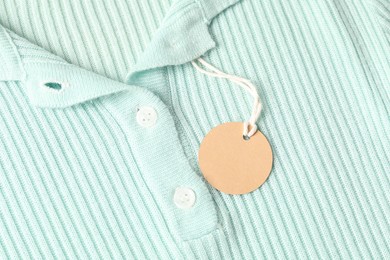 Photo of Cardboard tag on turquoise garment, top view
