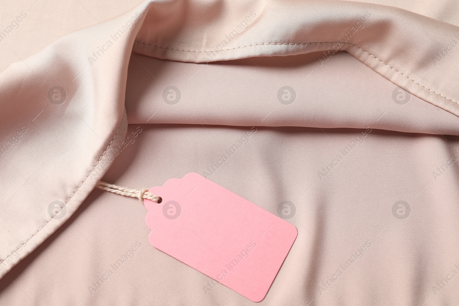 Cardboard tag on silk garment, top view Photo of Cardboard tag on silk garment, top view