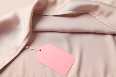 Photo of Cardboard tag on silk garment, top view