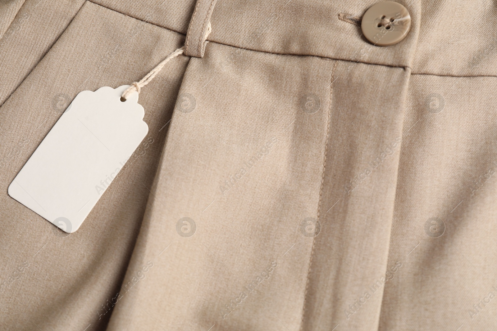 Cardboard tag on beige pants, above view Photo of Cardboard tag on beige pants, above view
