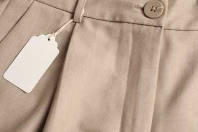 Photo of Cardboard tag on beige pants, above view