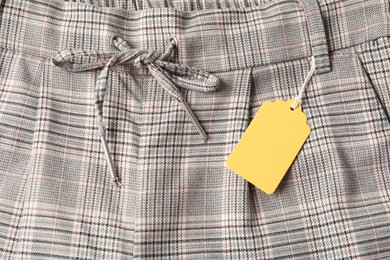 Photo of Cardboard tag on checkered pants, top view
