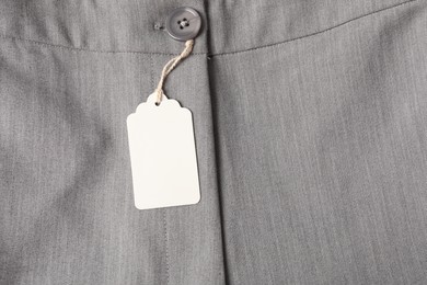 Photo of Cardboard tag on grey pants, top view