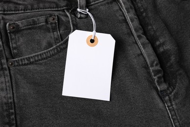 Photo of Cardboard tag on black jeans, top view